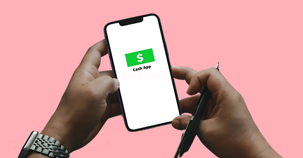 a person's hands holding a phone with the Cash App logo on the phone screen.