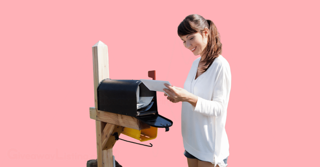 a happy woman standing beside her mailbox, picking up her packages.