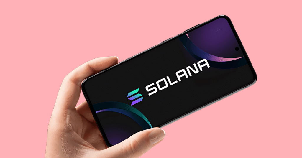 a person's hand holding a phone with the screen displaying the Solana text logo.