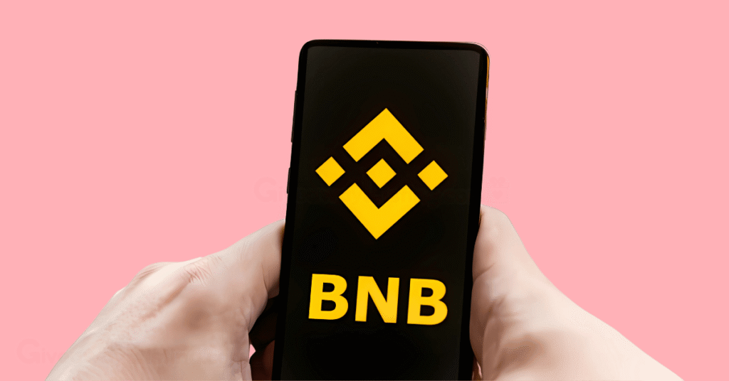 A person's hand holding a phone with the screen showing the BNB text and logo.