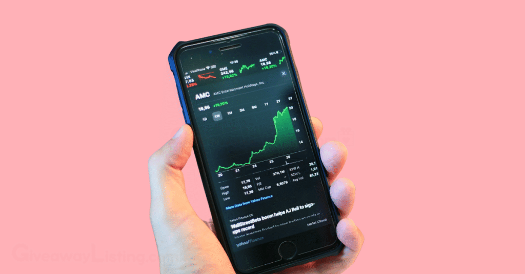 A person's hand holding a phone with the screen showing candlestick charts.